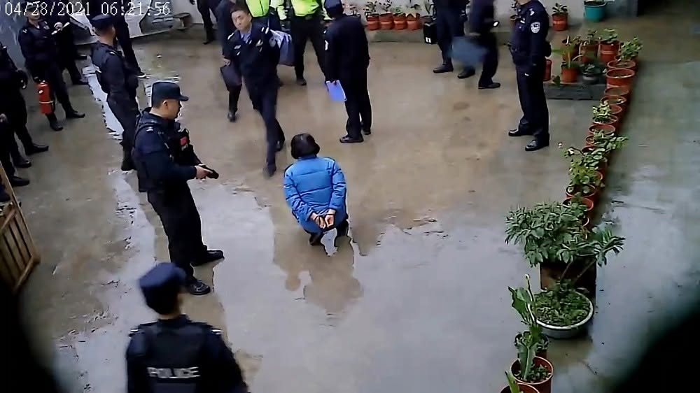 视频监控画面截图显示：清晨6点上百名全副武装的警察和特警鱼贯闯入仙韵家园大门，用铁般事实戳穿了起诉书 ...
